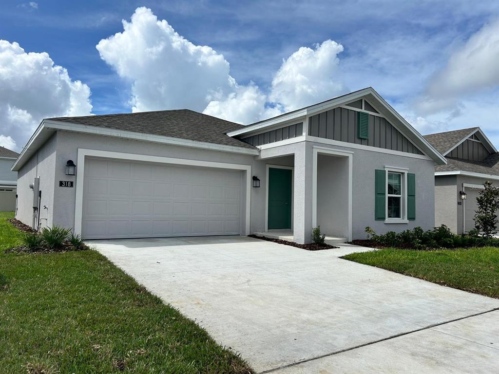 a front view of a house with yard and tress