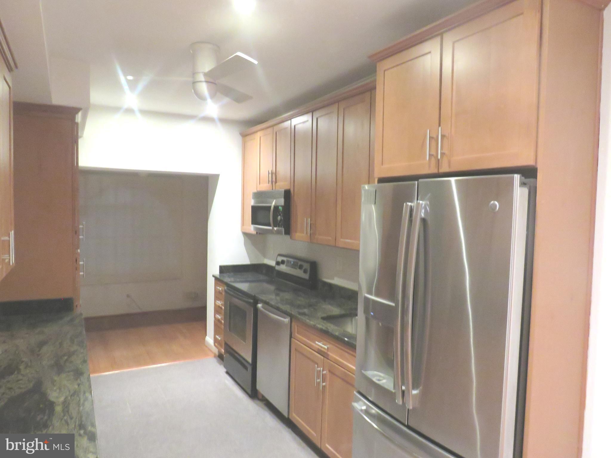 a kitchen with stainless steel appliances granite countertop a refrigerator and a sink