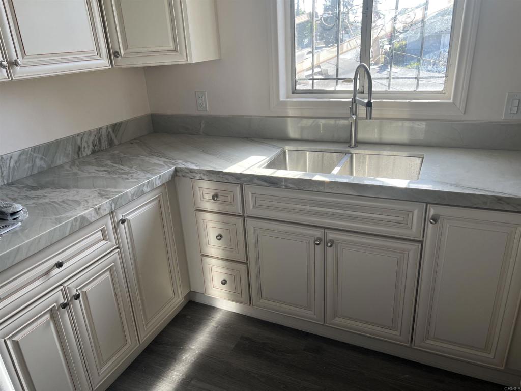 a kitchen with white cabinets and sink