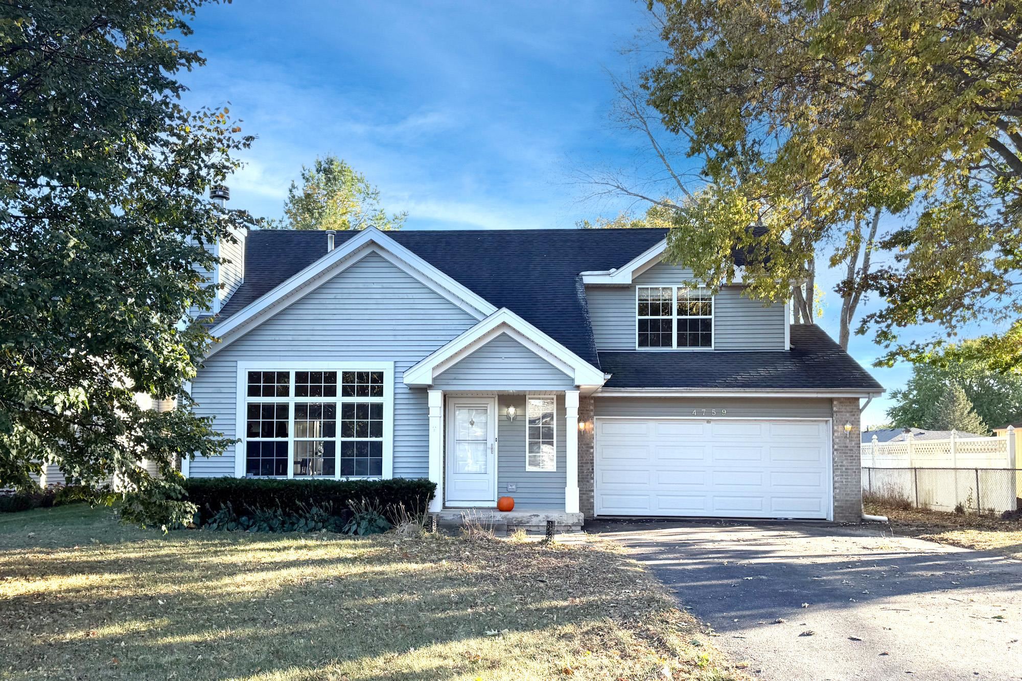 a view of a house with a yard and large tree