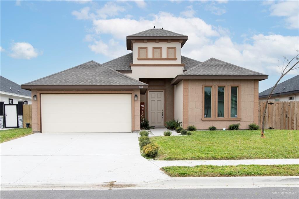 View of front facade with a front lawn and a garage