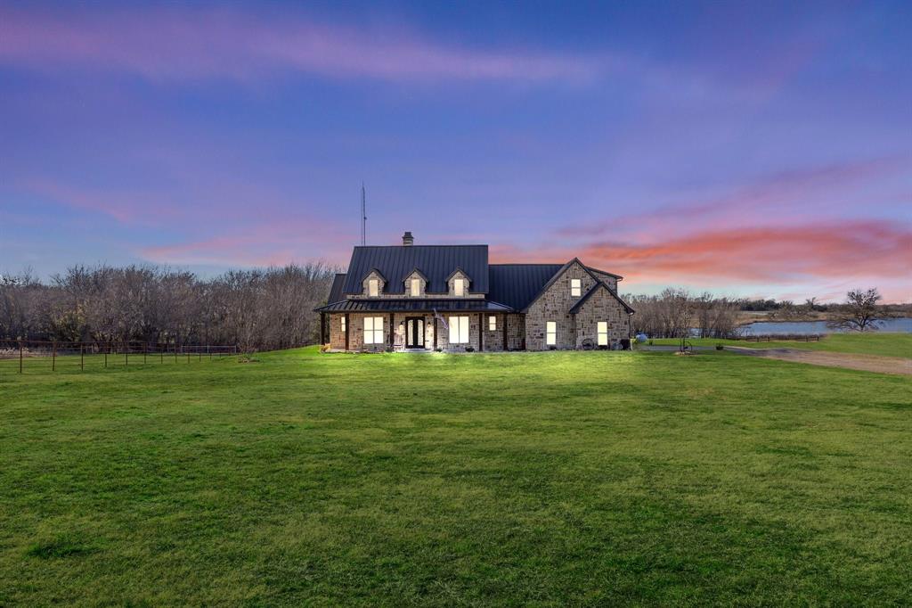 a view of a big house with a big yard and large trees