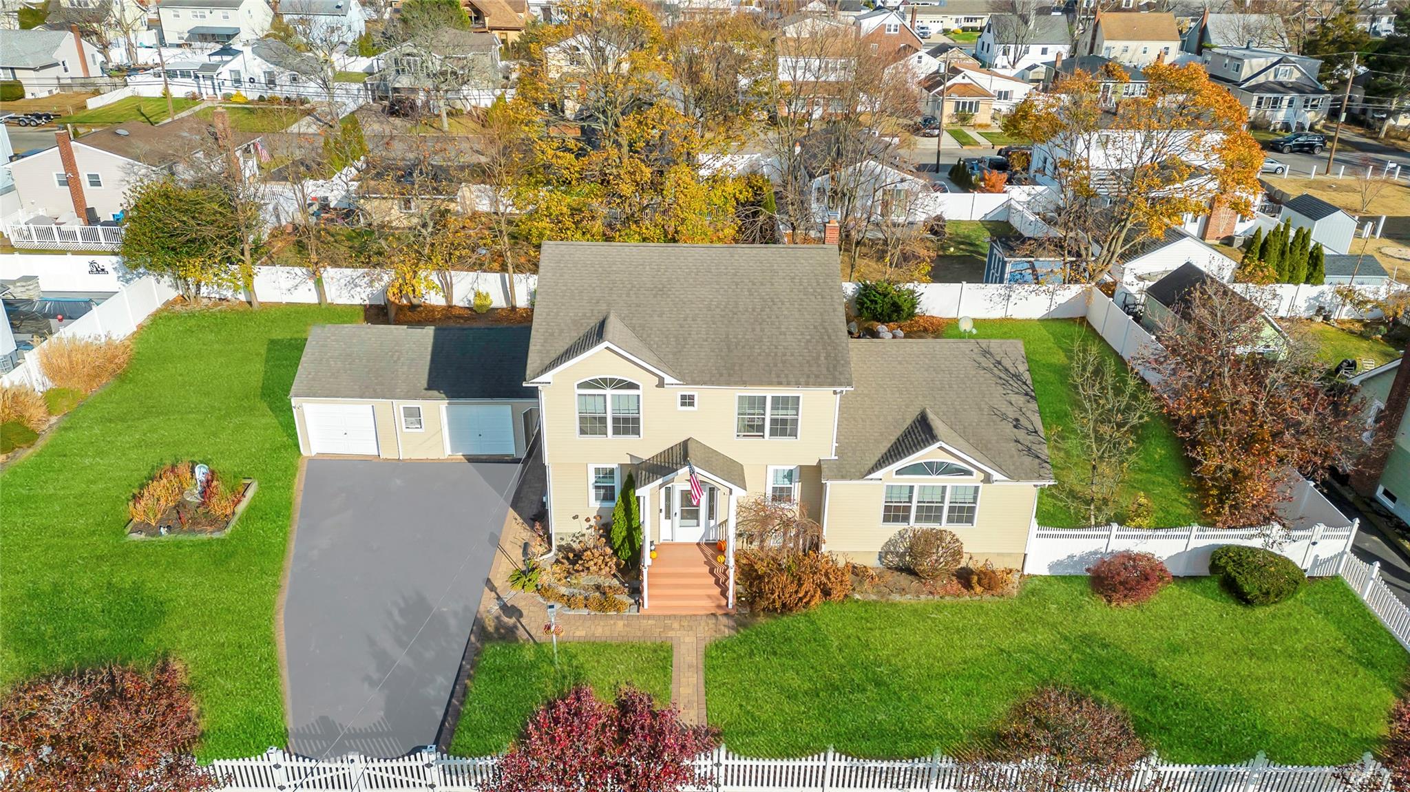 an aerial view of residential houses with outdoor space and trees