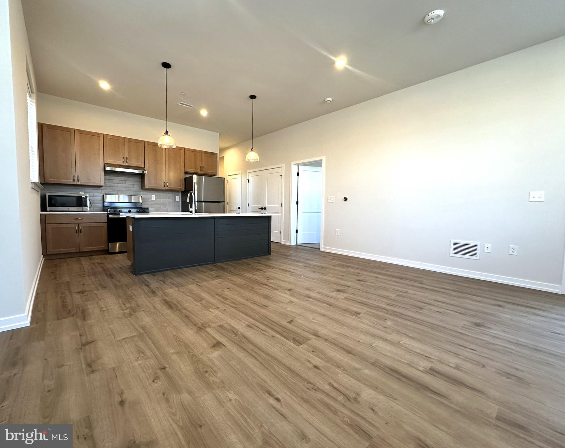 a view of kitchen with kitchen island sink stainless steel appliances and cabinets