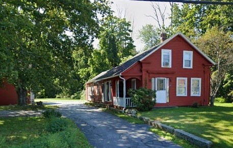 a front view of a house with yard and green space