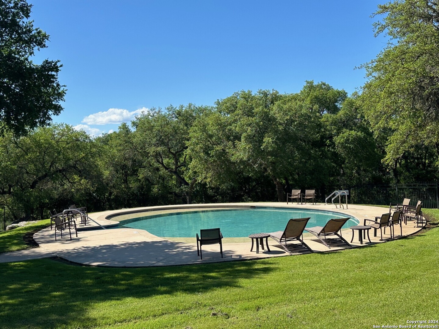 a view of a swimming pool with lawn chairs under an umbrella