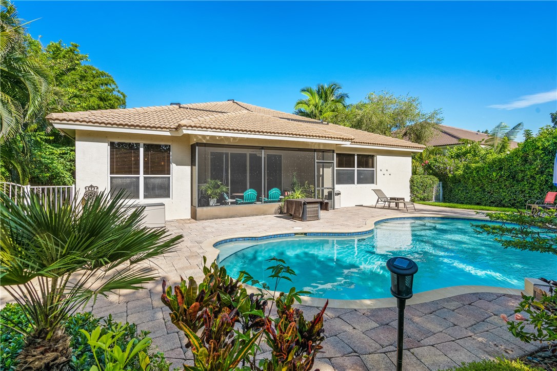 a view of a house with backyard sitting area and swimming pool