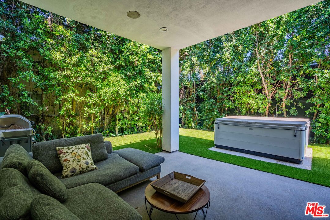 a backyard of a house with table and chairs a large tree