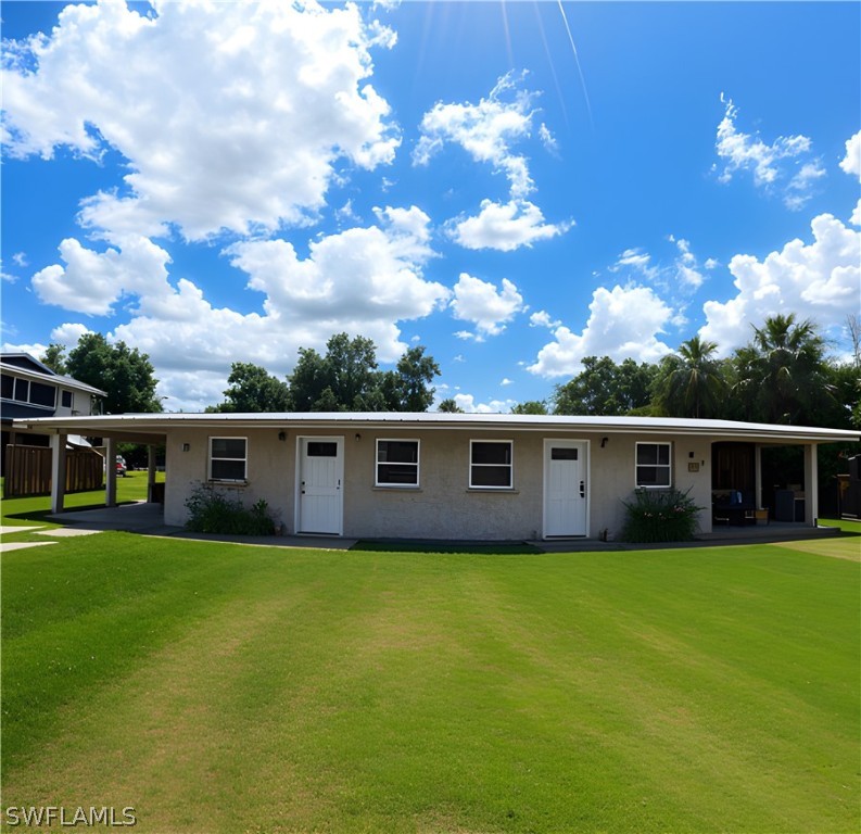 a view of a house with yard and sitting area