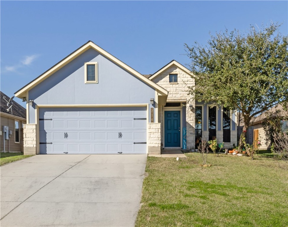 View of front of house with a garage and a front y