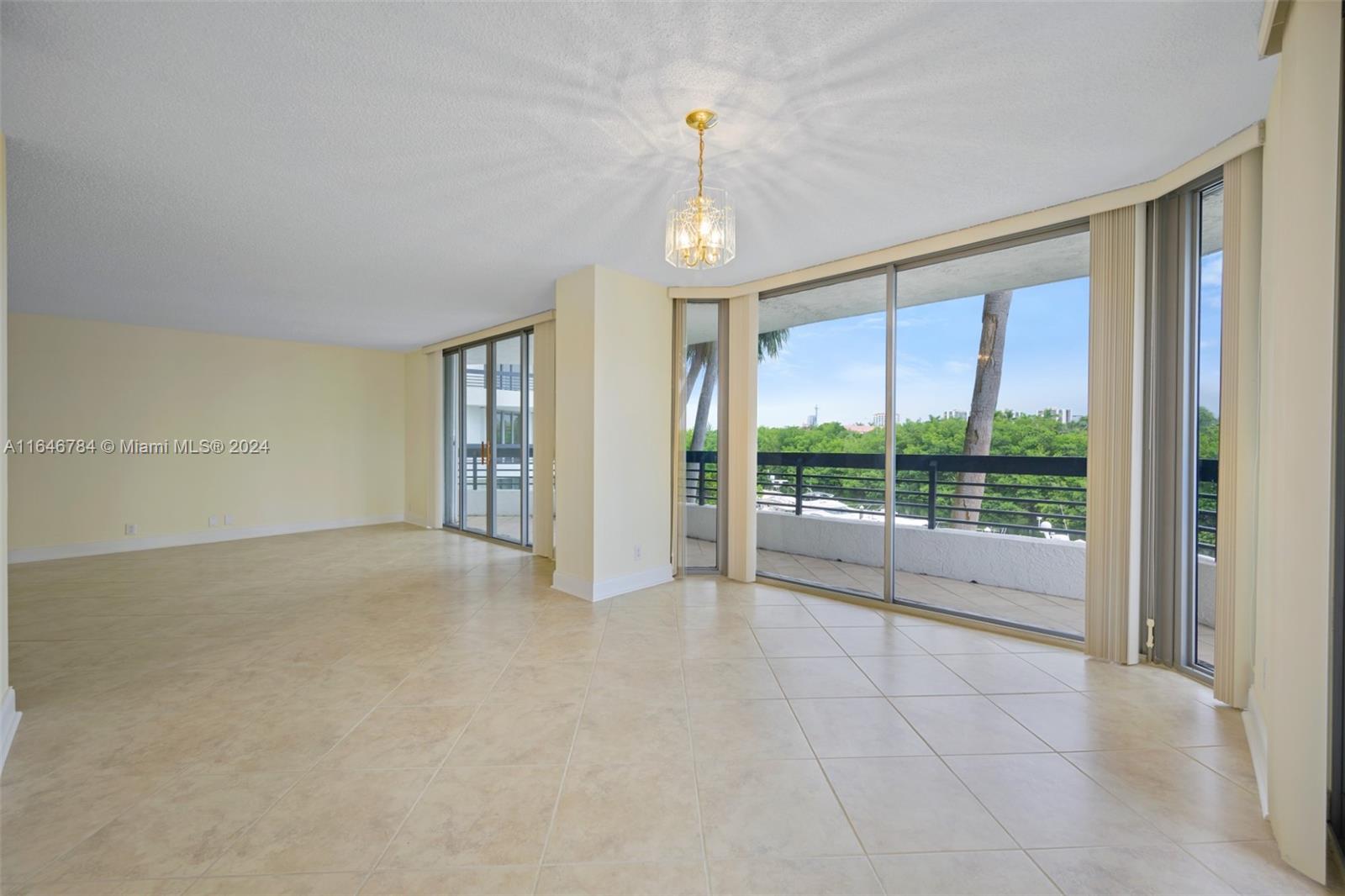 a view of an empty room with glass door and balcony