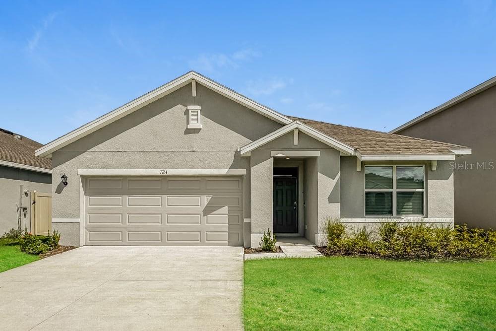 a front view of a house with a yard and garage