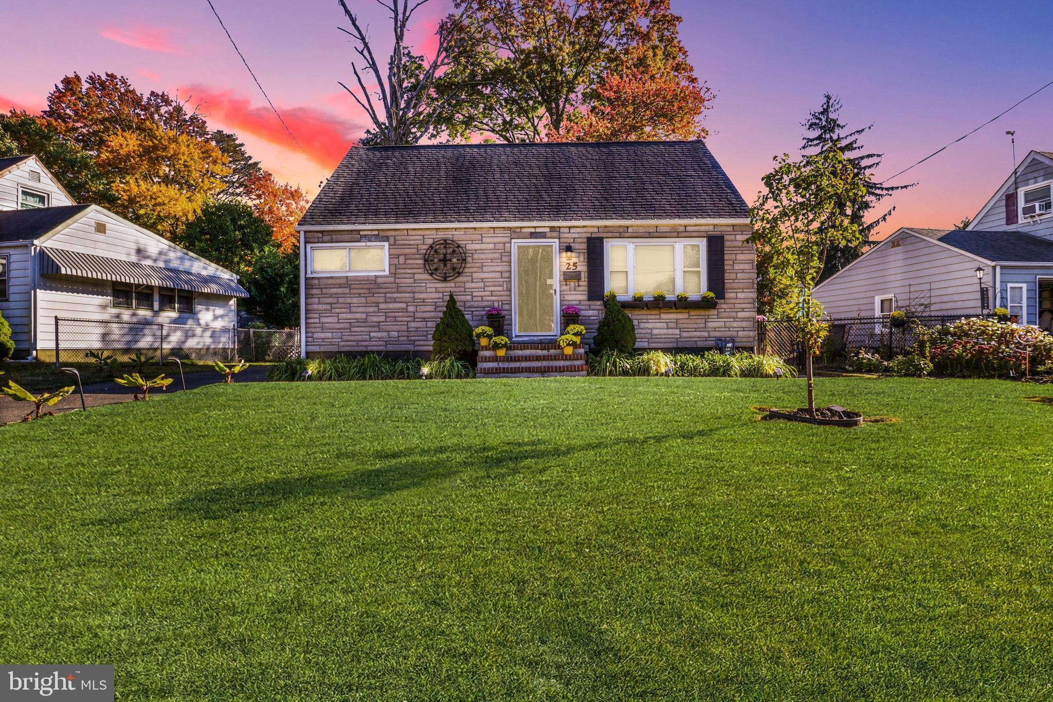 a front view of a house with a garden and trees