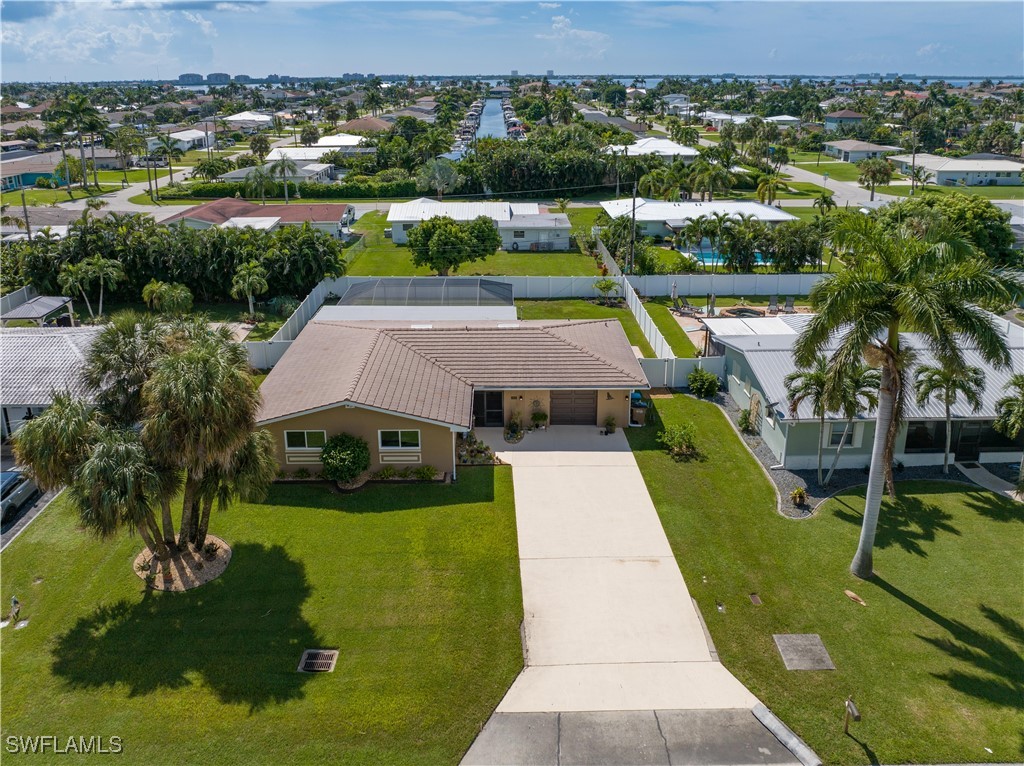 an aerial view of a house with swimming pool large trees and lake view