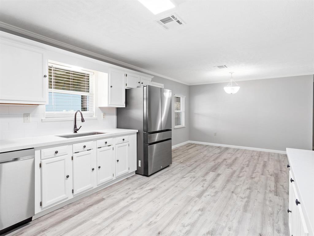 a kitchen with stainless steel appliances a refrigerator sink and cabinets