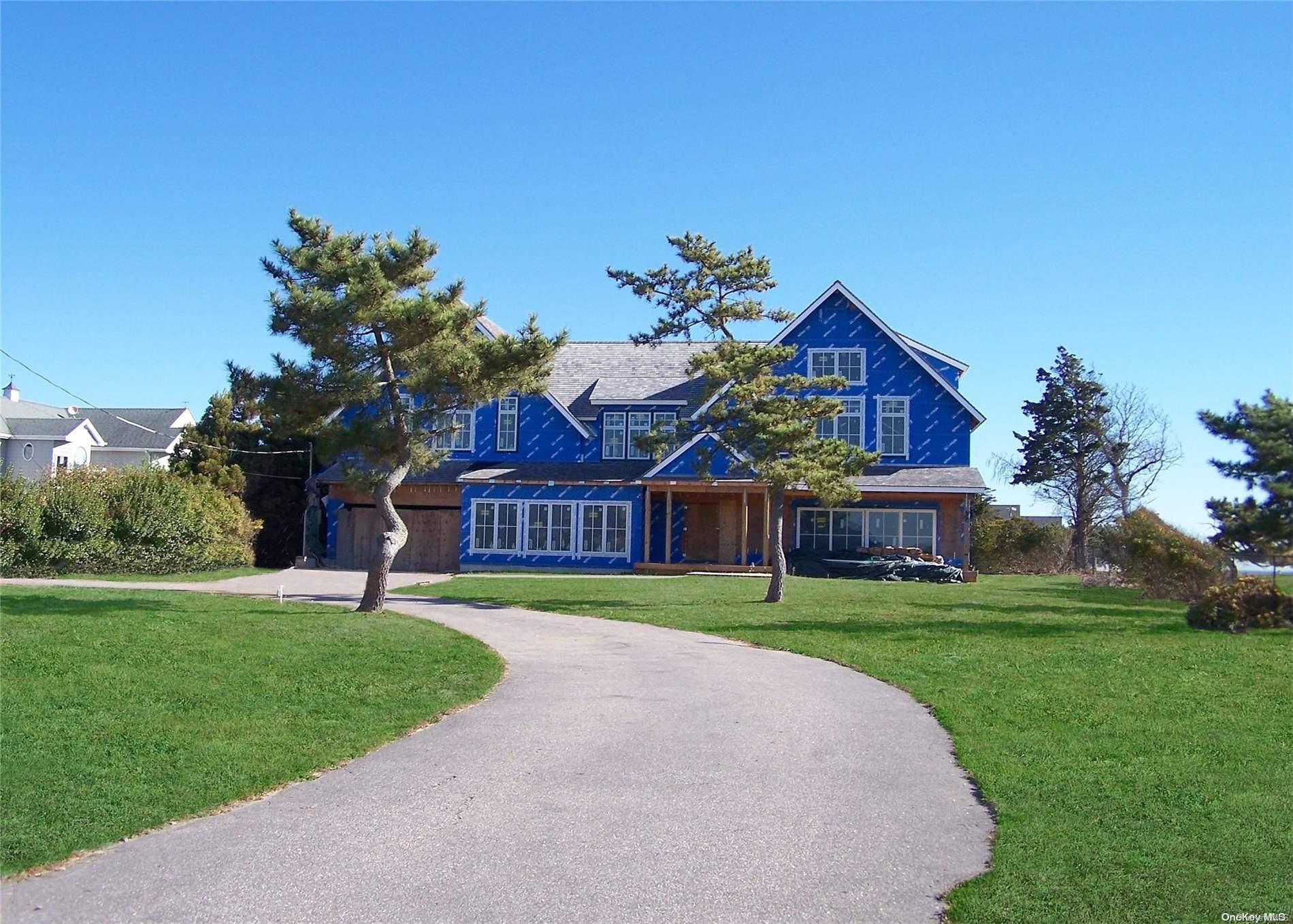 a view of a big house with a big yard and potted plants in front of house