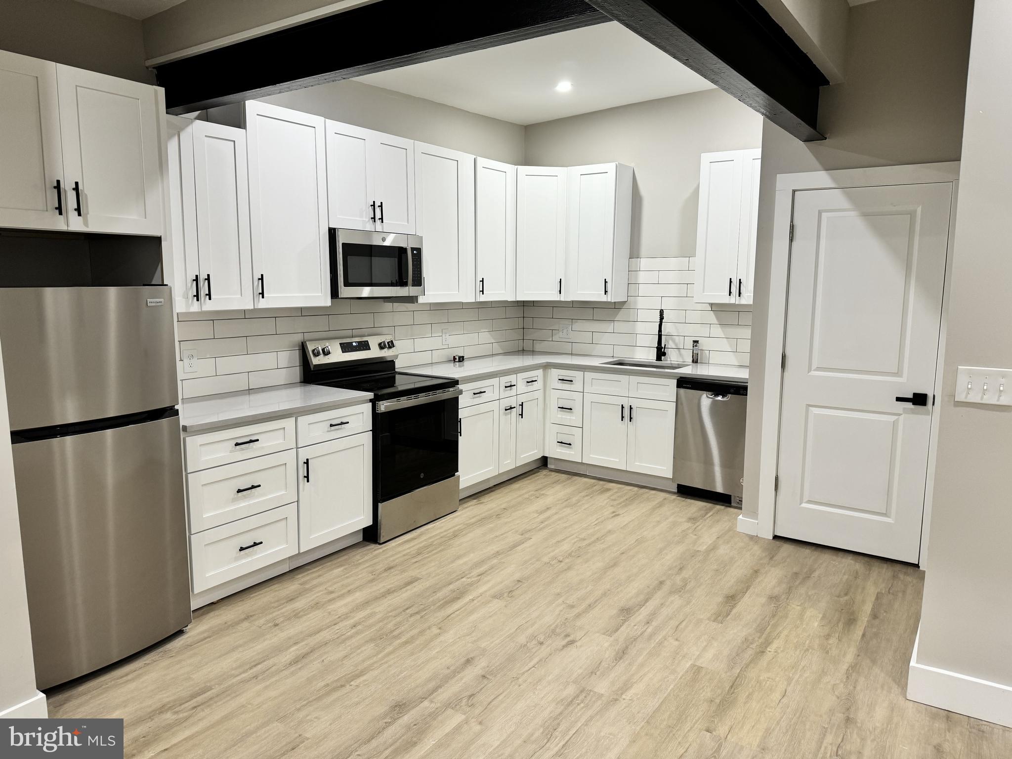 a kitchen with white cabinets and stainless steel appliances