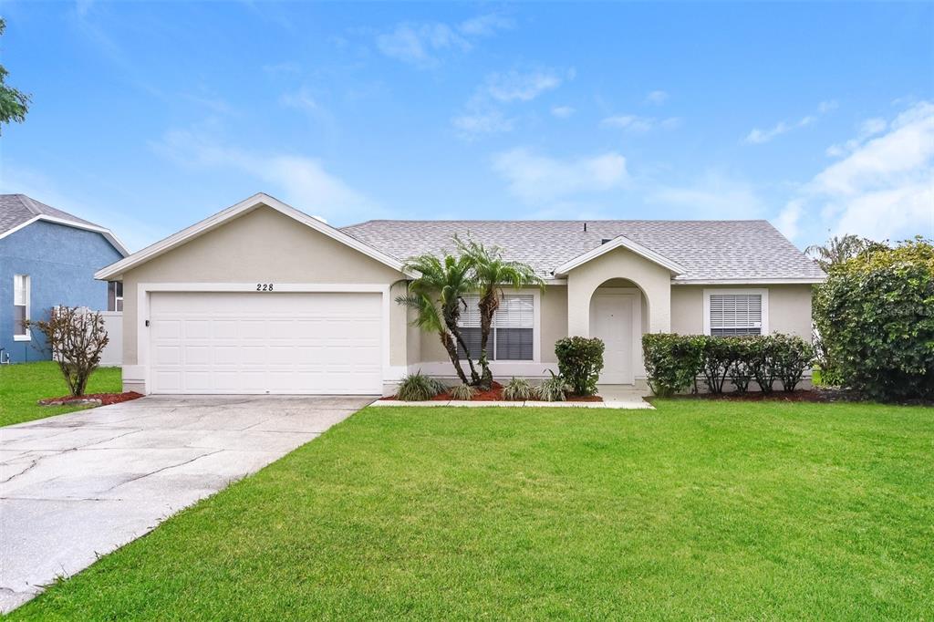 a front view of a house with a yard and garage