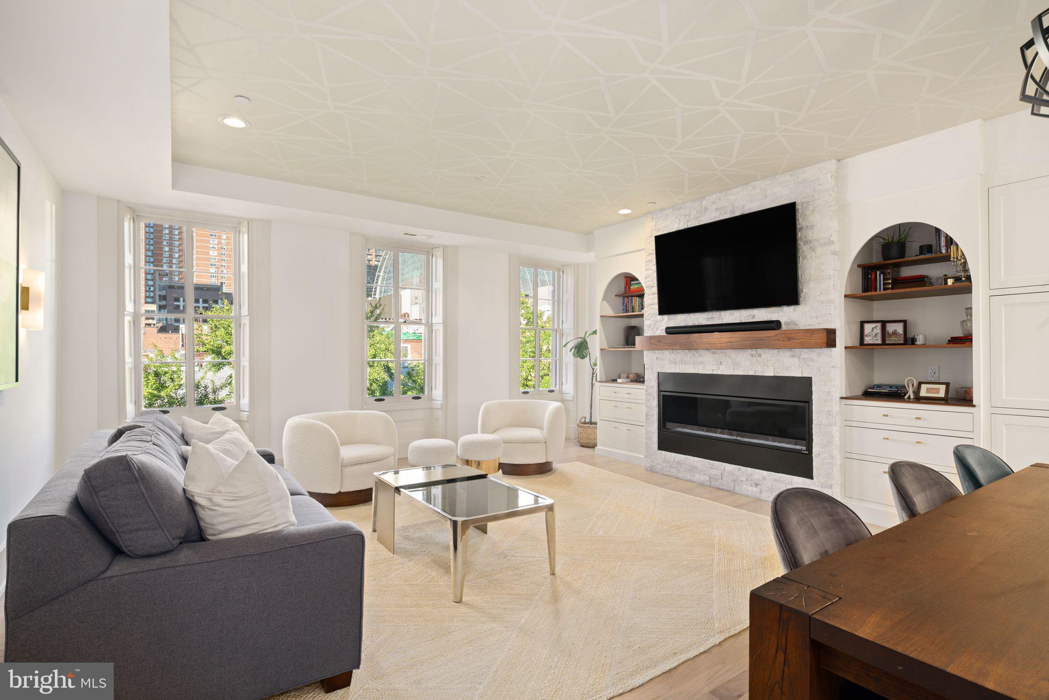 a living room with furniture a fireplace and a flat screen tv