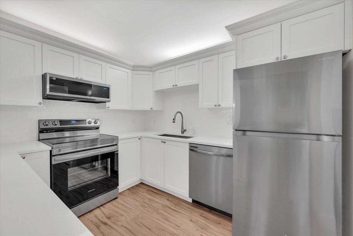 a kitchen with stainless steel appliances a refrigerator sink and microwave