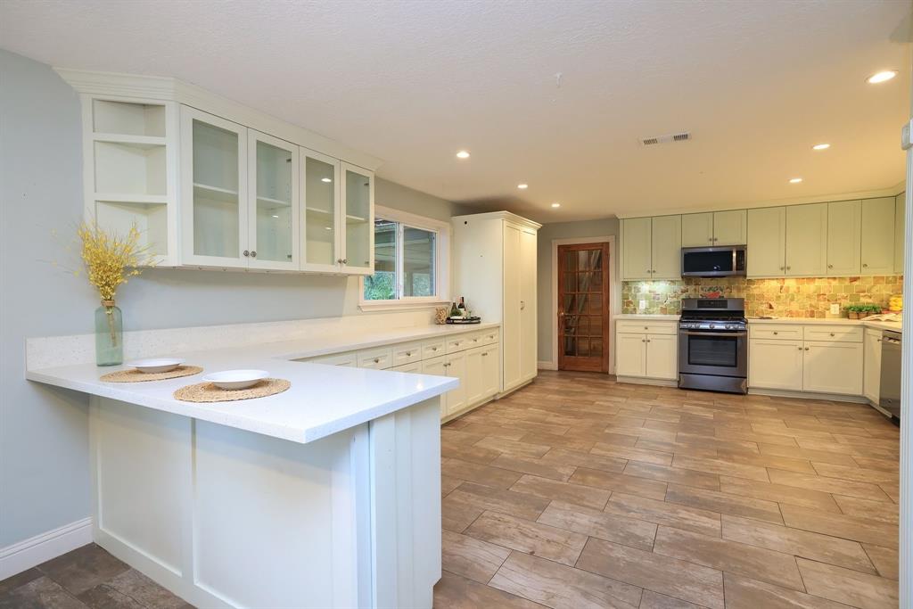 a kitchen with stainless steel appliances granite countertop a sink and a refrigerator