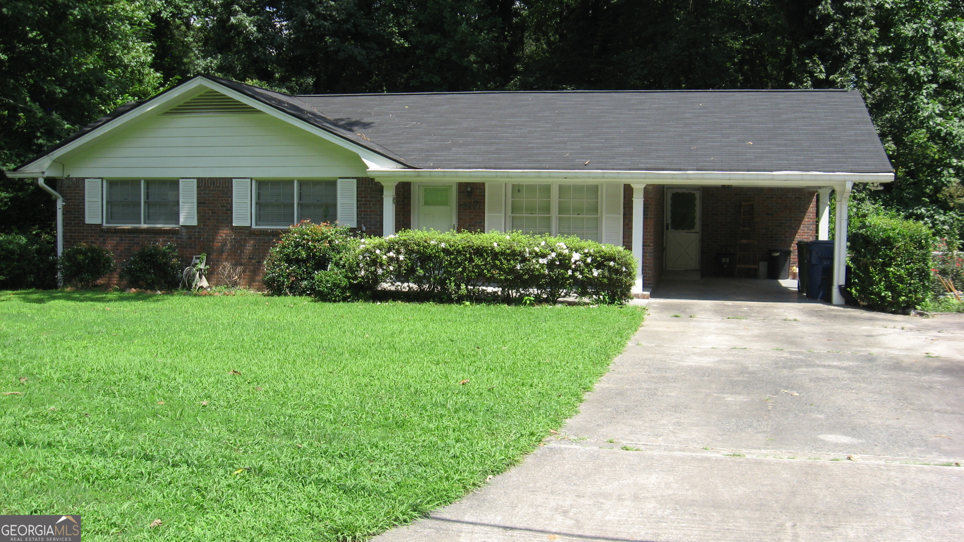 a front view of a house with a garden and yard