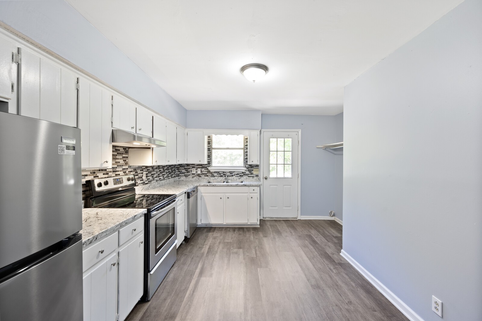 a kitchen with granite countertop white cabinets and white appliances