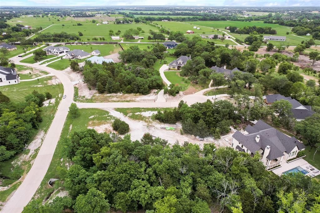 an aerial view of residential houses with outdoor space and trees