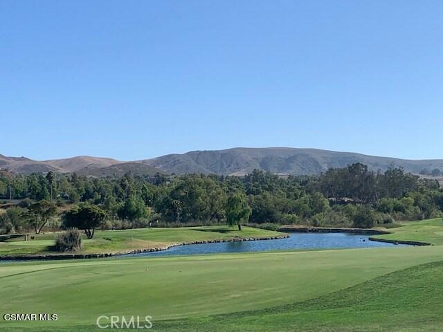 a view of a grassy field with mountains in the background