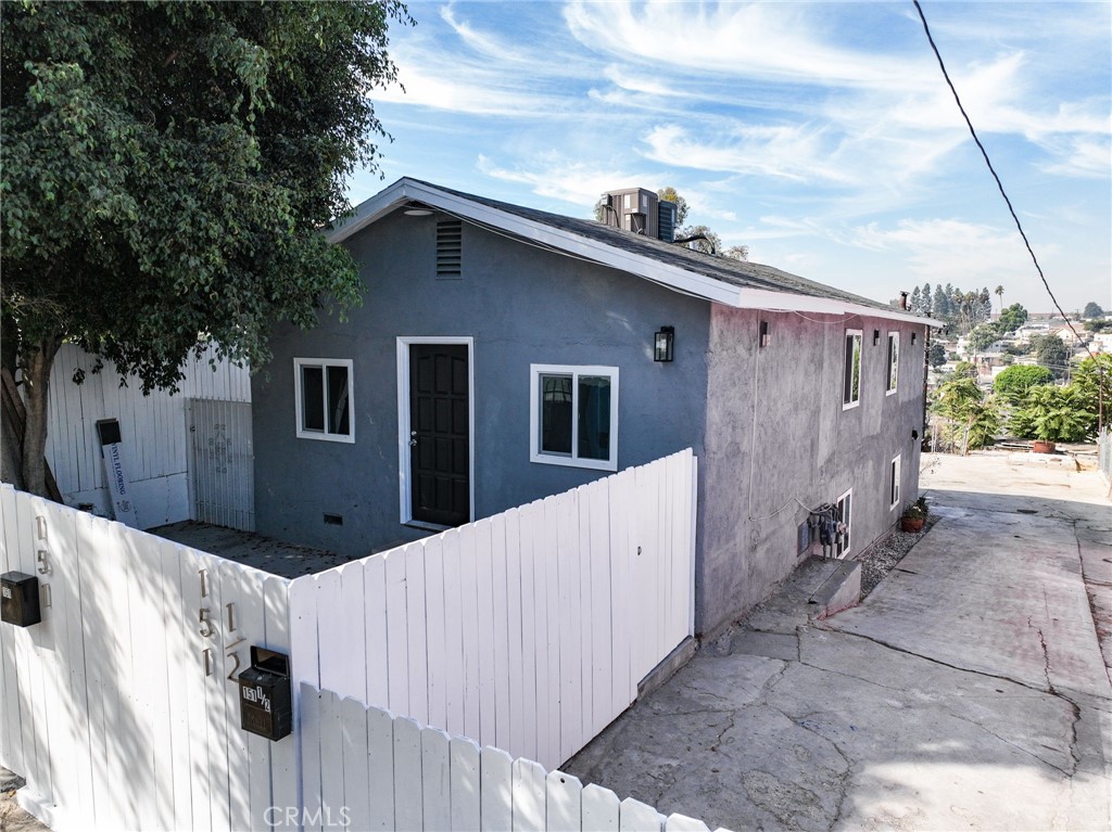 a side view of a house with wooden fence