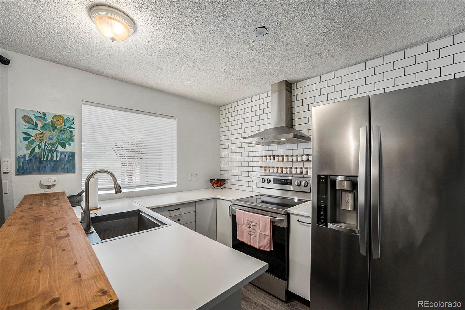 a kitchen with stainless steel appliances a refrigerator sink and stove