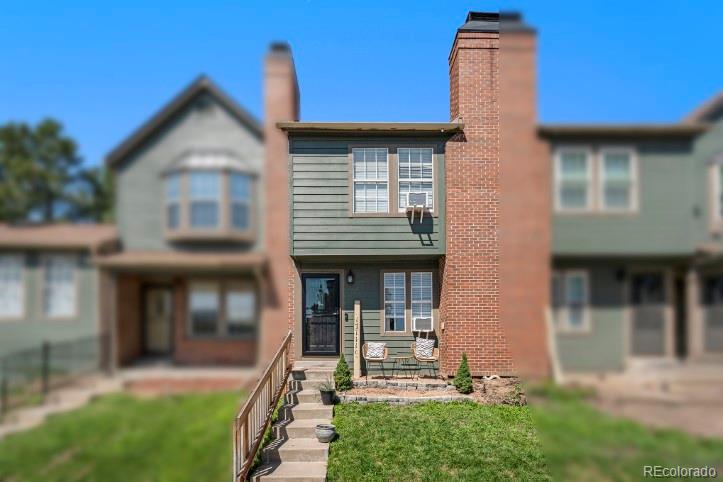 a view of a house with brick walls and a yard with plants