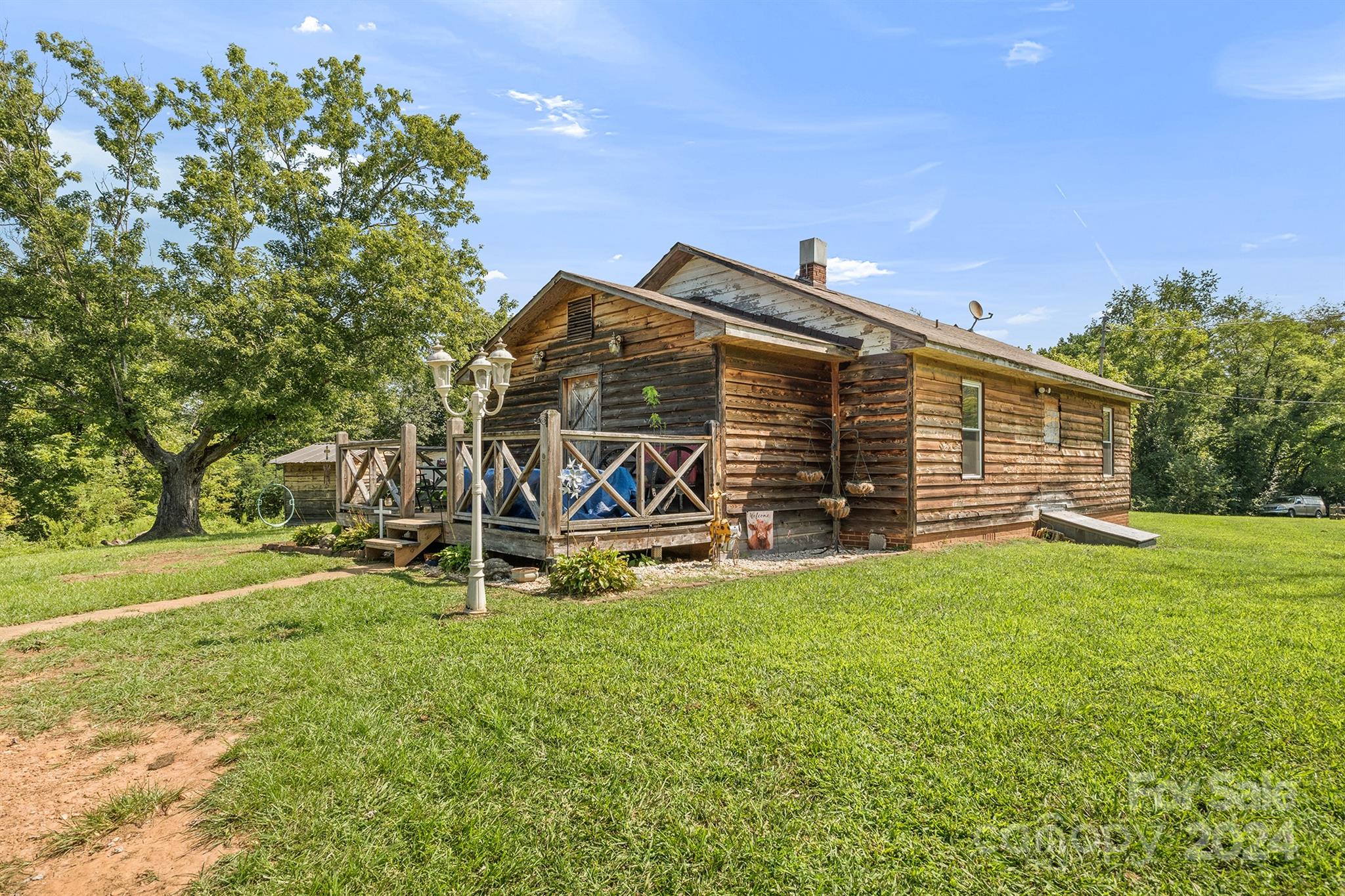 a view of a house with backyard and a tree