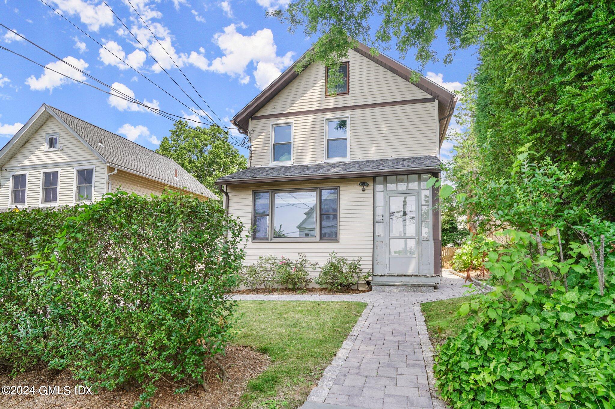 a front view of a house with a yard and trees