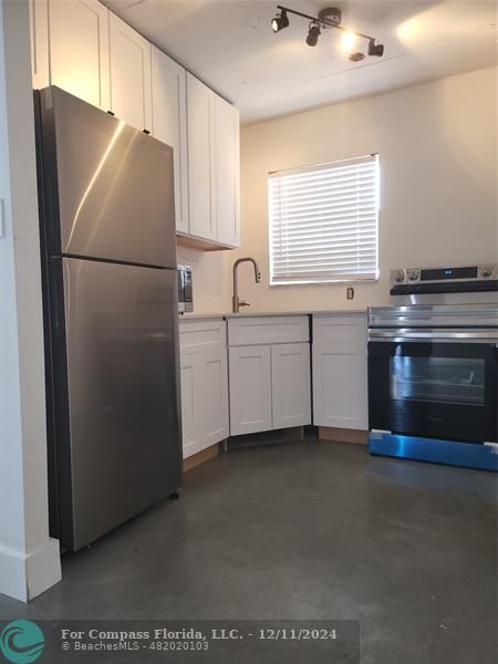 a kitchen with stainless steel appliances a refrigerator sink and cabinets