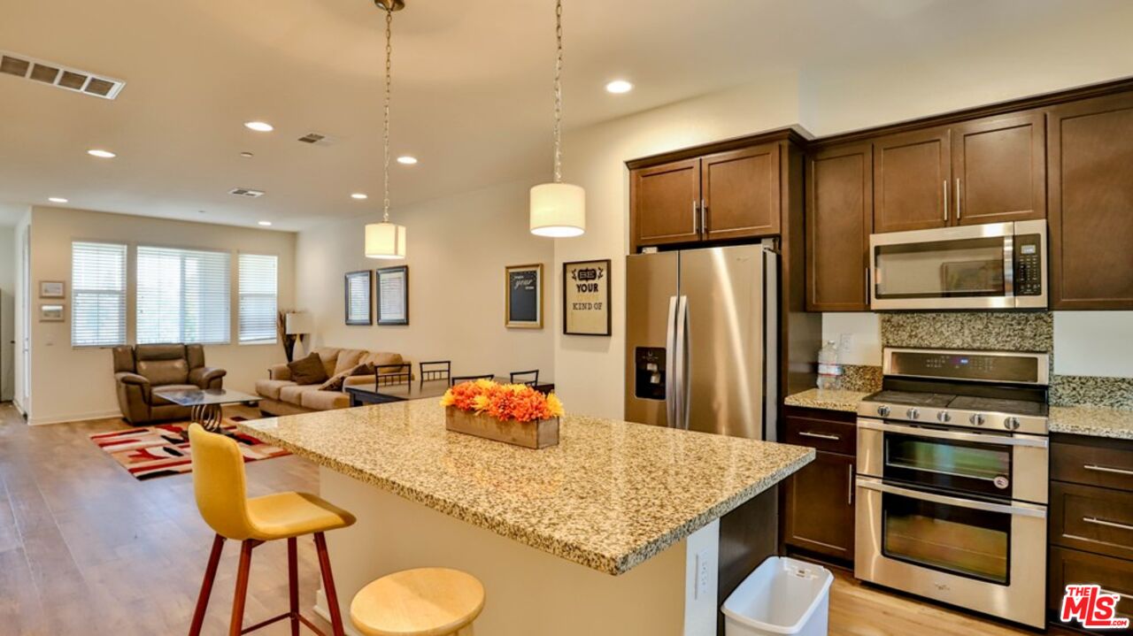 a kitchen with stainless steel appliances granite countertop a sink refrigerator and cabinets