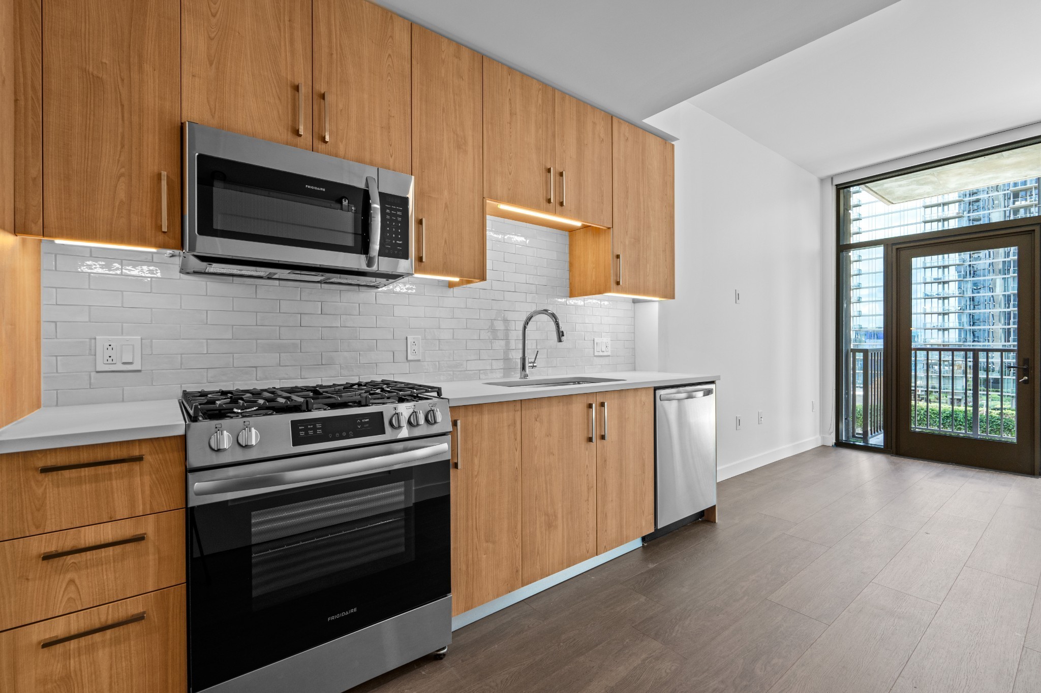 a kitchen with granite countertop cabinets stainless steel appliances and wooden floor