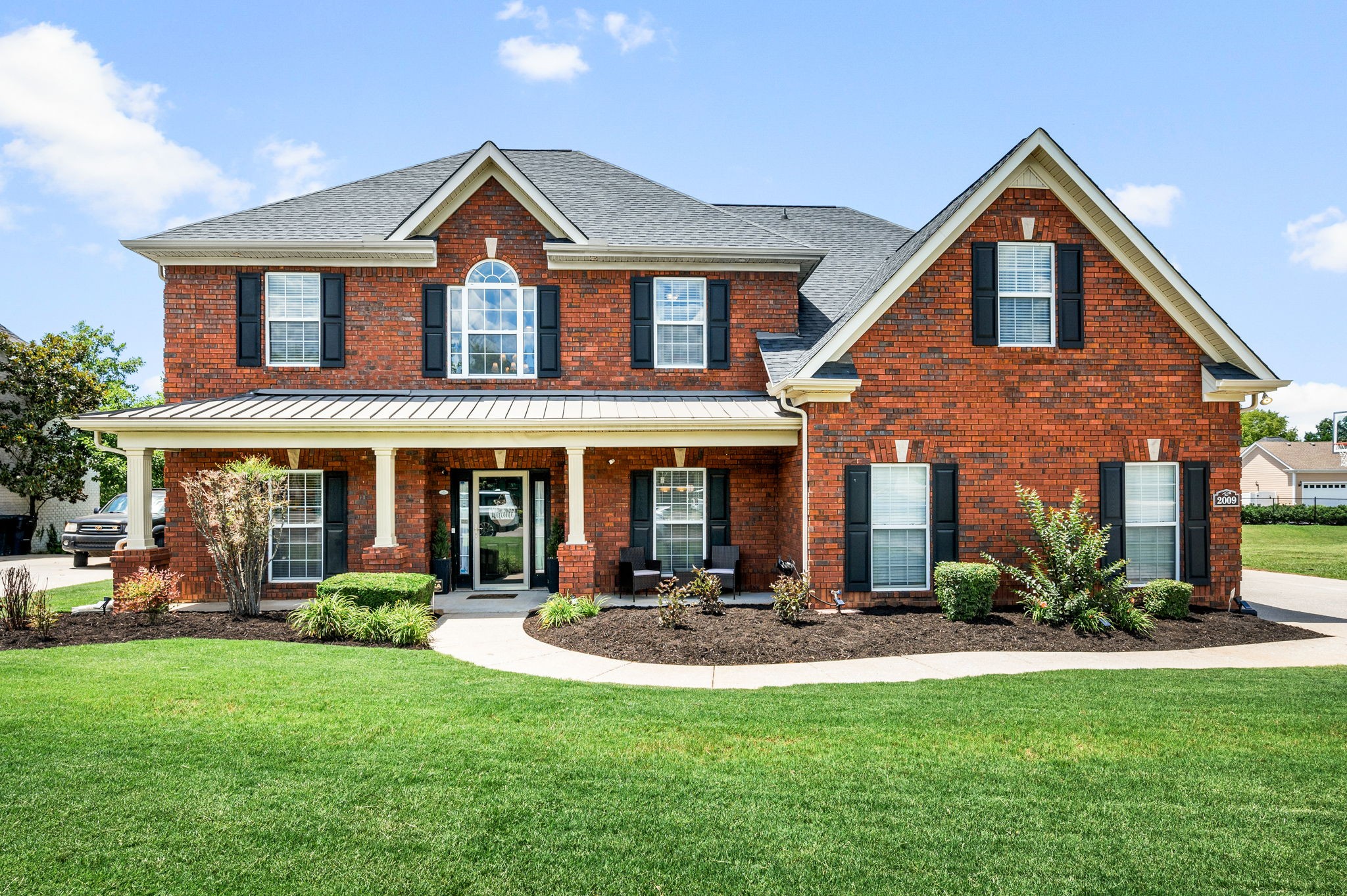 a front view of a house with a yard and porch