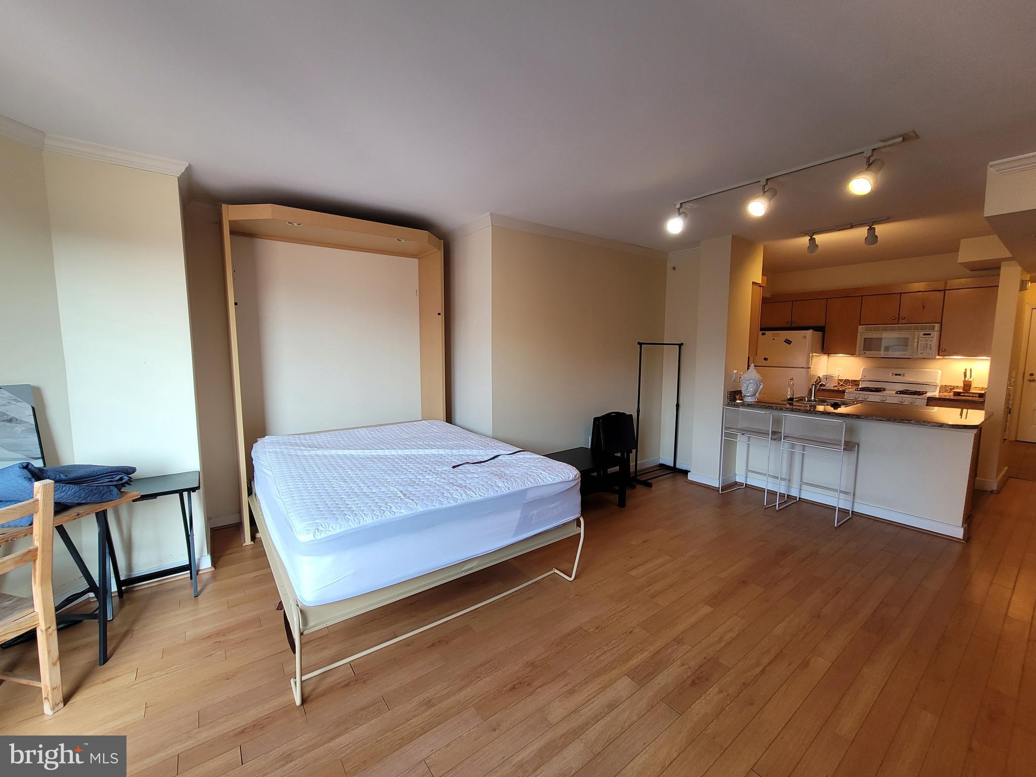 a bedroom with a bed and a view of kitchen