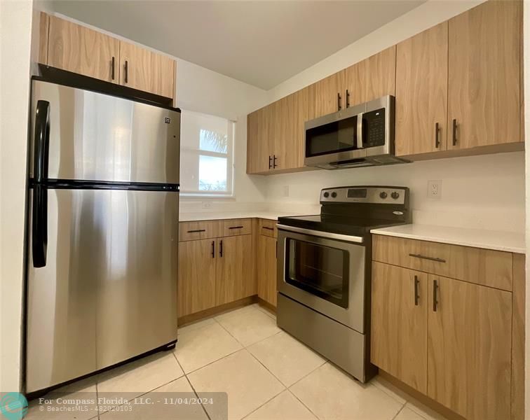 a kitchen with stainless steel appliances a refrigerator stove and microwave