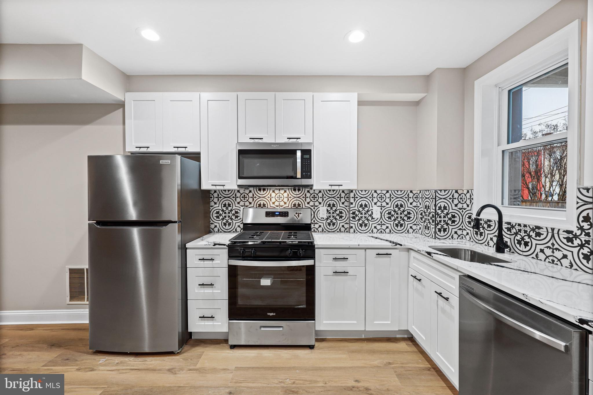 a kitchen with a refrigerator stove and sink