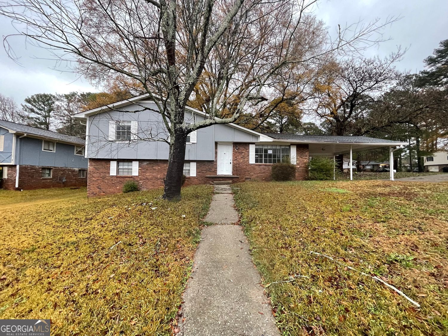 a front view of a house with a yard and trees