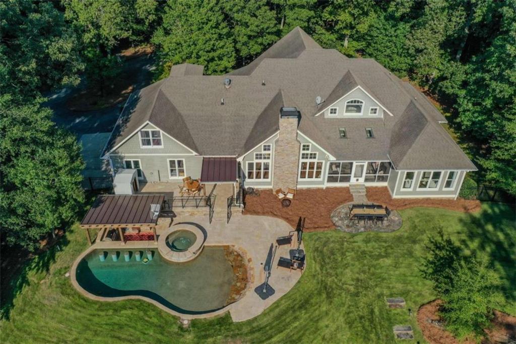 an aerial view of a house with swimming pool and big yard