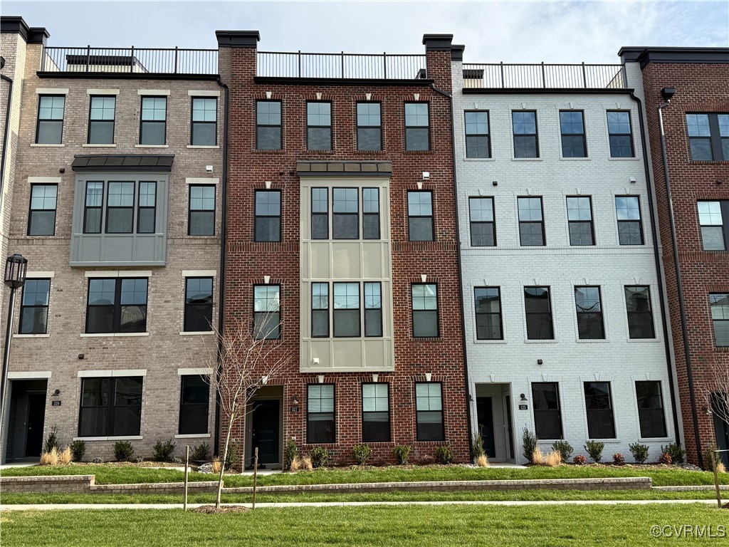 a tall building sitting in front of a big yard