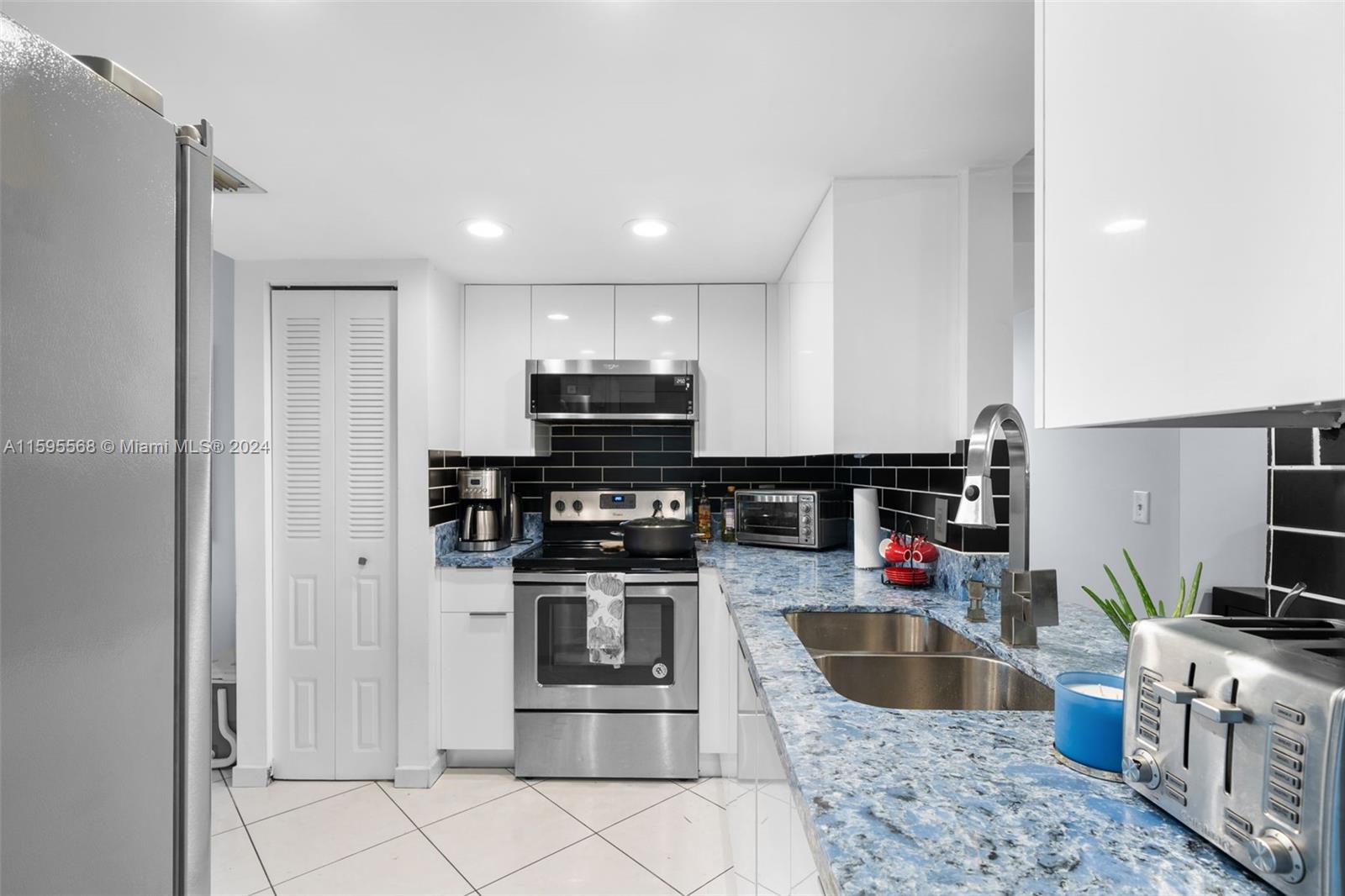 a kitchen with stainless steel appliances granite countertop a refrigerator and a sink