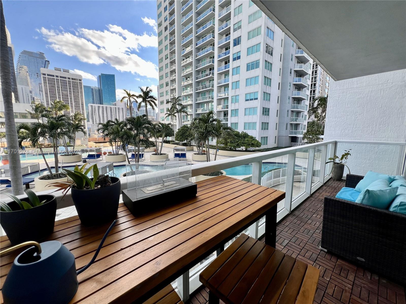 a view of a rooftop deck with couch and chairs