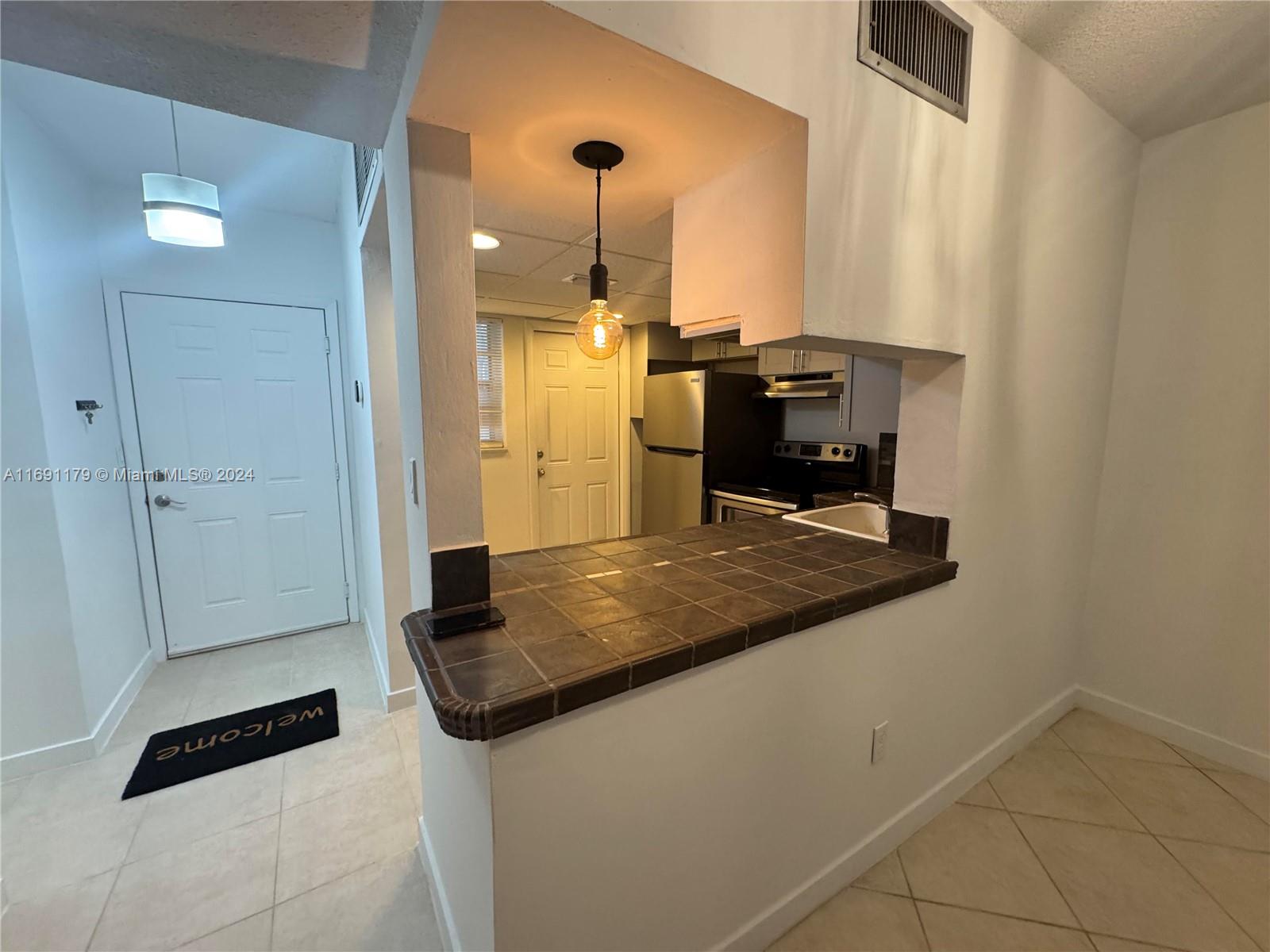 a kitchen with stainless steel appliances granite countertop a sink and a refrigerator