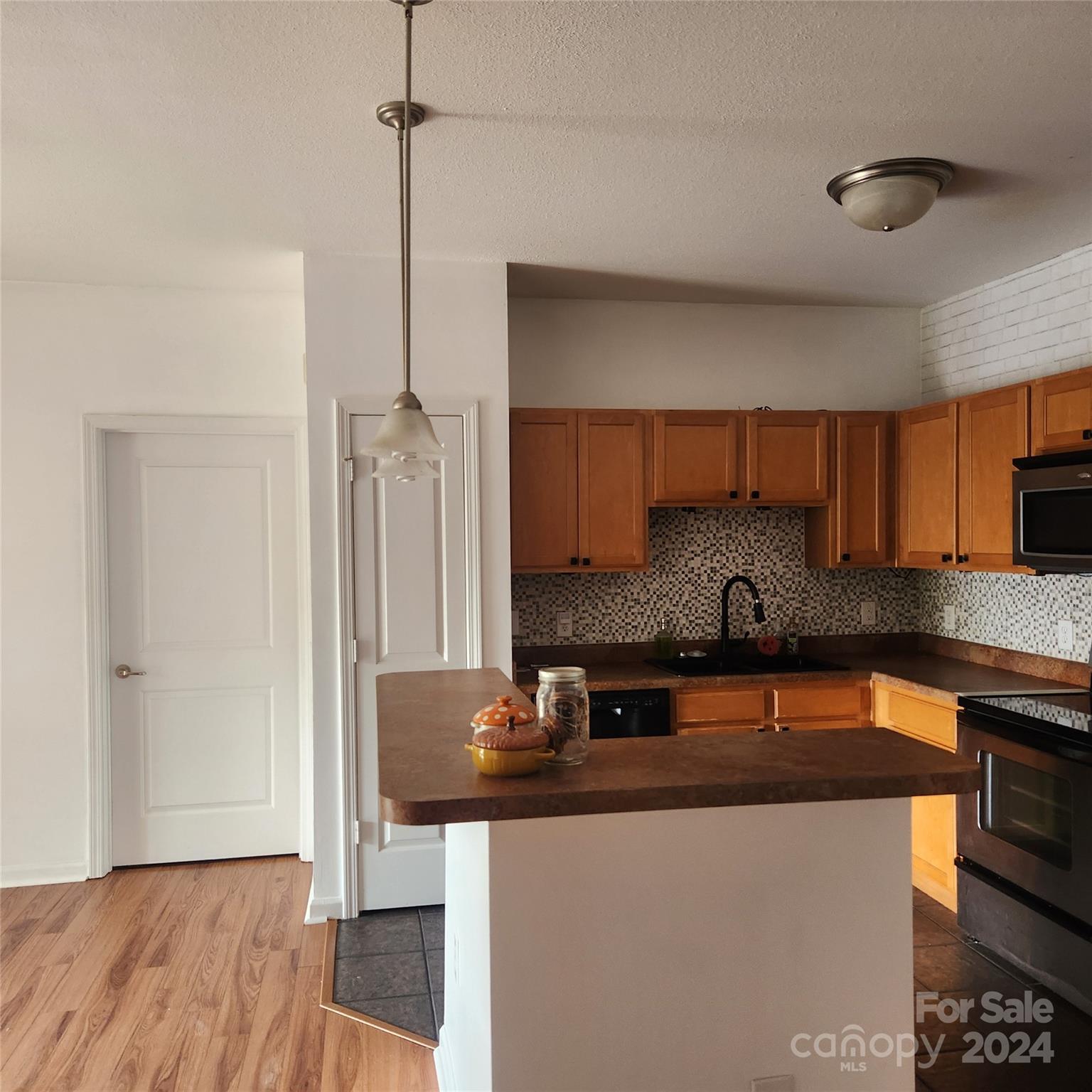 a kitchen with a sink a refrigerator and cabinets