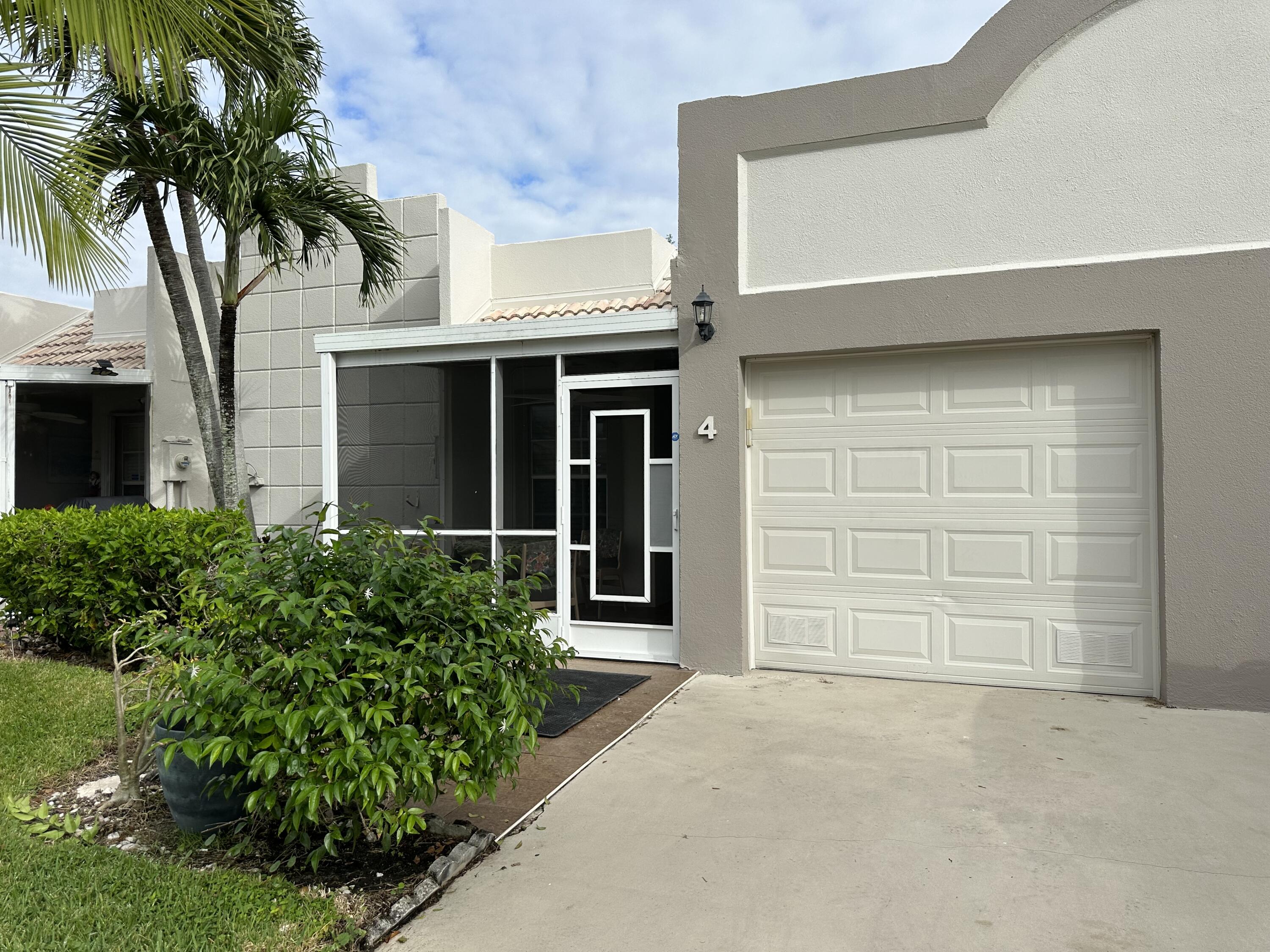 front view of a house with a potted plant and a garage