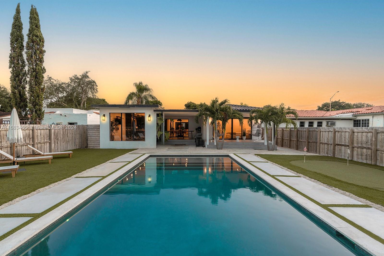 a view of a house with pool and a yard